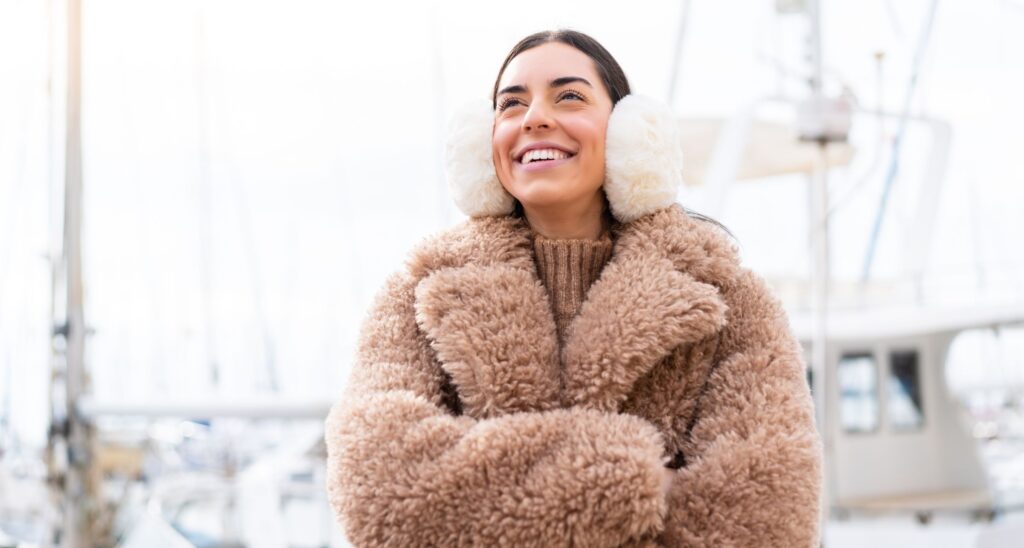 Ragazza con pelliccia e paraorecchie in inverno.